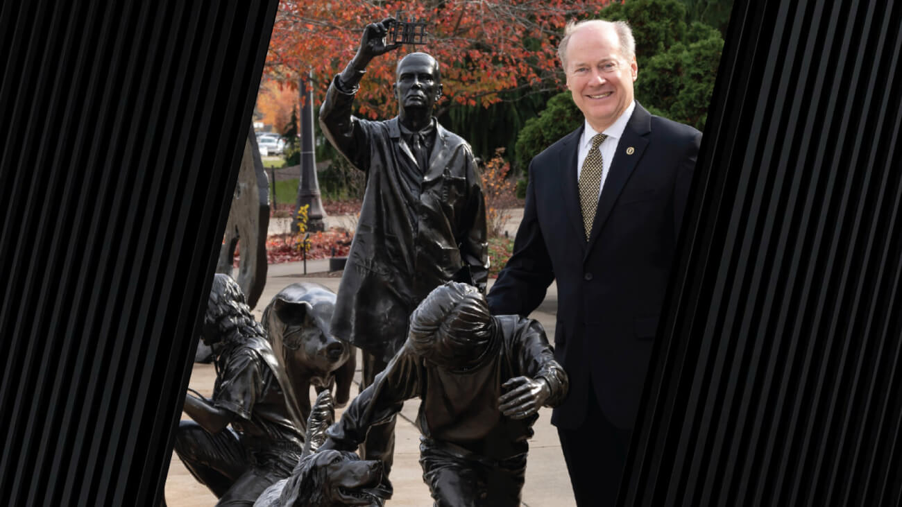 Dean Bret Marsh standing next to the Continuum Sculpture at Lynn Hall